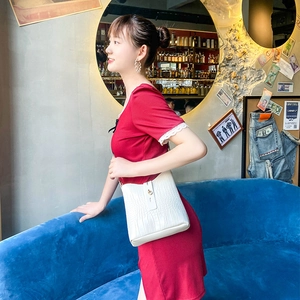 Elegant white crocodile pattern hobo bucket bag with golden lock on a model
