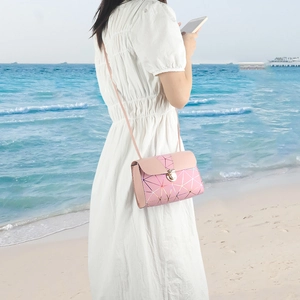 Pink geometric pattern shoulder bag with gold lines and silver metal clasp on model