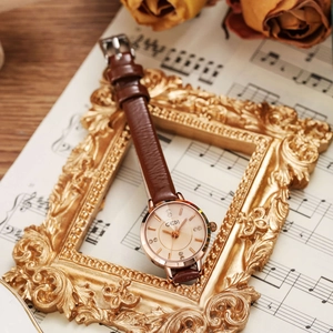 Elegant vintage women's watch with brown leather strap and rose gold rhinestone dial