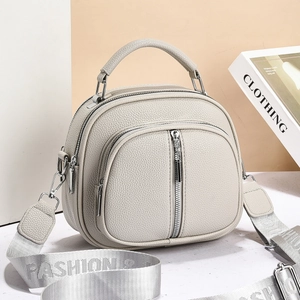 Detail of lychee pattern leather bag with dual zipper compartments and fashion strap
