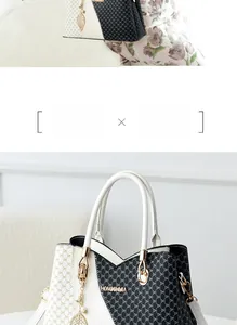 Detail of elegant black and white tote bag with DH pattern and gold leaf charm
