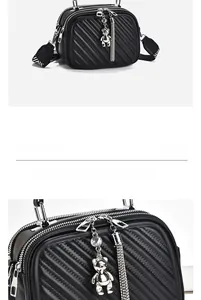 Detail of black quilted shoulder bag featuring a metallic bear charm and tassel