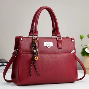 Sac à main chic en cuir bordeaux texturé avec boucle argentée et pendentif décoratif