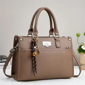 Vue détaillée du sac à main en cuir synthétique marron avec breloques et cloches