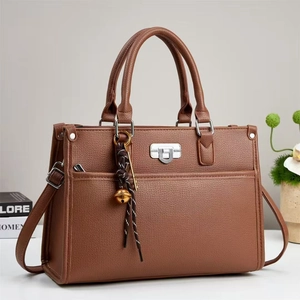 Détail du sac à main en cuir synthétique marron avec fermoir argenté et décoration