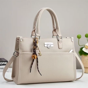 Vue détaillée du sac à main en cuir synthétique beige avec fermoir en métal argenté