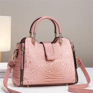 Close-up of pink crocodile pattern leather bag with polished gold zipper and hardware