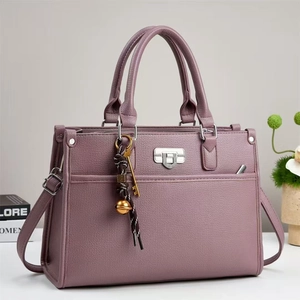 Détail du sac à main en similicuir mauve avec texture litchi et boucle argentée
