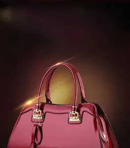 Close-up of elegant burgundy patent leather handbag with polished gold zipper and hardware