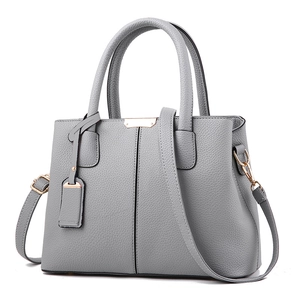 Elegant grey lychee pattern leather handbag with gold hardware and detachable strap