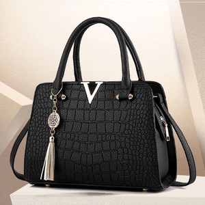 Sac à main noir motif crocodile avec boucle en V dorée et détail de gland élégant