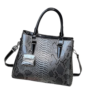 Retro faux snakeskin tote bag with top handle and mini bag charm on white background