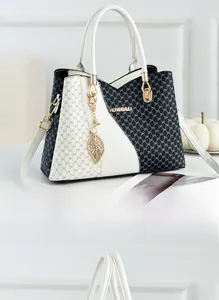 Detail of black and white tote bag with golden leaf charm and DH monogram print