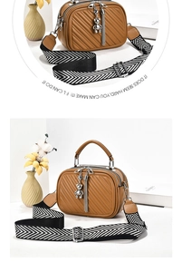 Close-up of quilted shoulder bag with metal bear charm and dual zipper compartments