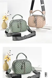 Detail of V-quilted handbags with bear pendant and stylish wide woven shoulder strap