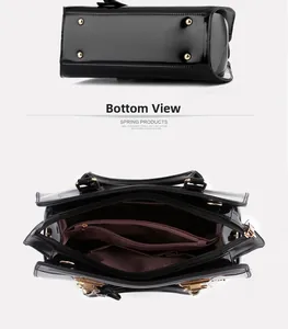 Detail view of glossy leather bag with protective metal feet and multi-compartment interior