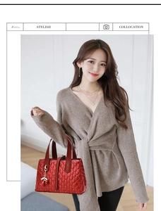 Details einer roten gesteppten Brauthandtasche mit Kirsch-Charm und Ledergriffen