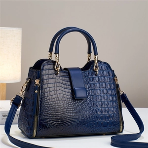 Luxurious deep blue crocodile pattern handbag with top handles and gold hardware detailing
