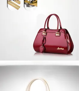 Detailed close-up of glossy burgundy patent leather handbag with gold metal hardware
