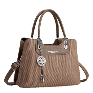 Brown woven texture handbag with silver chain and leather straps on white background