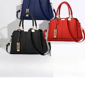 Dettaglio di grandi borse a mano in blu navy, nero e rosso con texture in pelle litchi
