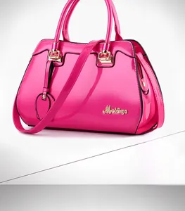 Macro shot of rose red patent leather handbag with gold metal hardware and logo detail