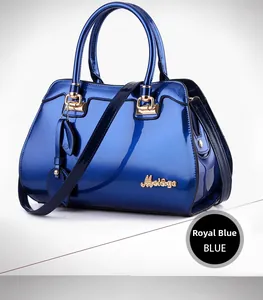 Close-up of royal blue glossy patent leather handbag with gold-tone hardware detail
