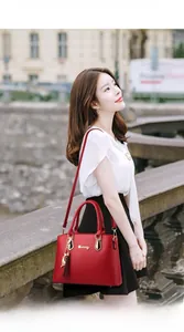 Detail of red tote bag with golden hardware, tassel charm, and adjustable shoulder strap