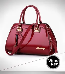 Close-up of wine red patent leather handbag featuring shiny finish and gold metal hardware