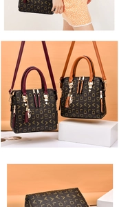 Detail of black crossbody bag with gold DIALDAL print, tassels and adjustable strap
