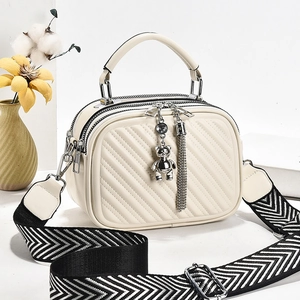 Chic beige quilted crossbody handbag with silver bear charm and striped wide shoulder strap