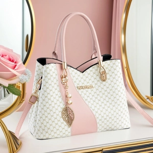 Pink and white monogrammed tote bag with pearl leaf charm and elegant shoulder strap