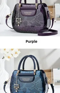 Detail of glossy faux snake skin texture and metal cat pendant on patent leather handbag