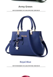 Close-up of royal blue litchi leather bag featuring a bow decoration and gold charms