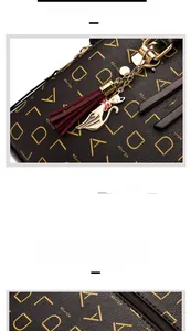 Detail of dark brown PU leather handbag featuring gold letter print and cat tassel charm