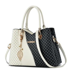 Chic black and white monogram tote bag with gold leaf pendant and dual handles