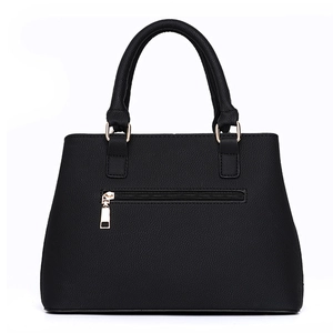 Detail of black pebbled leather handbag featuring gold zipper pocket and metal ring hardware