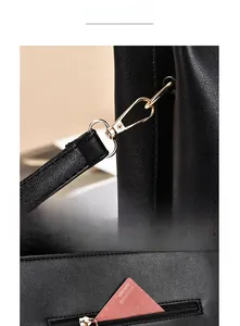 Detail of lychee pattern leather handbag with gold hardware clasp and rear zipper pocket