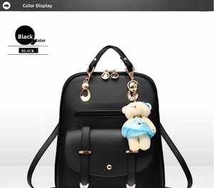 Front detail of black leather backpack featuring decorative metal cat ears and bear charm