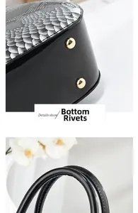 Detail view of the black patent leather handbag base with protective gold metal studs
