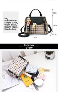 Detail view of plaid crossbody bag interior capacity with bear charm and metal buckle
