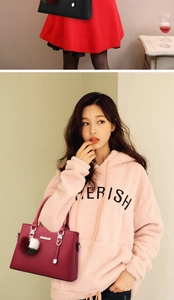 Close-up of leather handbags with pompom charms and winter fashion outfit detail