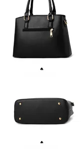 Detail view of the black handbag showing gold back zipper pocket and bottom protective feet