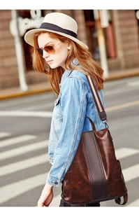 Close-up of brown vintage leather backpack with textured stripes and woven strap detail