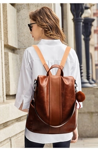 Brown vintage faux leather backpack with anti-theft rear zipper and plush pompom charm