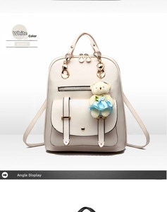 Detail view of a white PU leather backpack featuring a cute bear plush and gold hardware