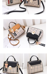 Detail of plaid crossbody bag featuring retro lock, leather handle, and bear charm
