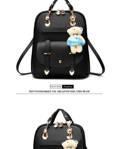 Front view of black leather backpack with gold heart hardware and cute teddy bear pendant