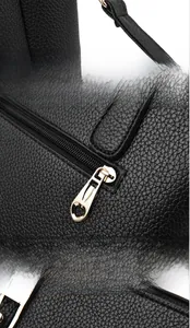Detail of light gold hardware including heart zipper puller and metal lobster clasp