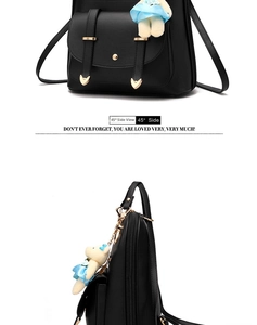 Detail view of black PU leather backpack with gold heart hardware and a cute teddy bear charm